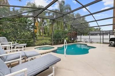a swimming pool in a pavilion with a bench and a pool at Indian Ridge - Pool Home with Spa, Newly Renovated in Orlando