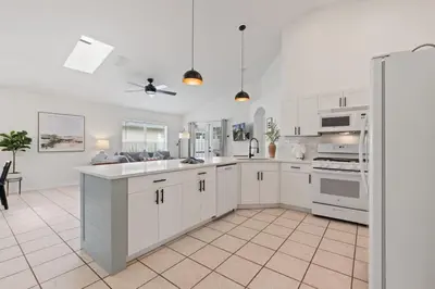 a large white kitchen with white cabinets and appliances at Indian Ridge - Pool Home with Spa, Newly Renovated in Orlando