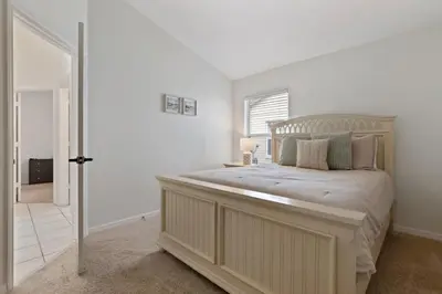 a bedroom with a large bed in a white room at Indian Ridge - Pool Home with Spa, Newly Renovated in Orlando