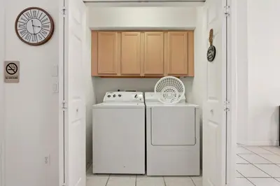 a kitchen with a washing machine and a clock at Indian Ridge - Pool Home with Spa, Newly Renovated in Orlando