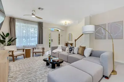 a living room with a couch and a table at Immersive Themed Villa in Resort 4mi to Disney with Game Room and Private Pool in Orlando