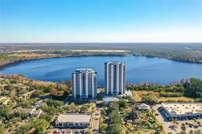 an aerial view of two tall buildings next to a lake at Blue Heron Beach Resort pet friendly in Orlando