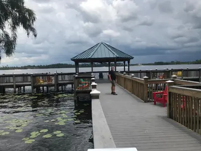a man standing in a gazebo next to the water at Blue Heron Beach Resort pet friendly in Orlando