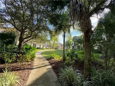 a walkway through a park with palm trees at Quiet Disney Condo w/ Balcony ~ 2 Miles to Disney World! in Orlando
