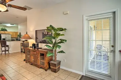 a living room with a potted plant and a kitchen at Quiet Disney Condo w/ Balcony ~ 2 Miles to Disney World! in Orlando