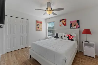 a bedroom with a white bed and a ceiling fan at Enjoyable 6BR Home Near Disney in Orlando