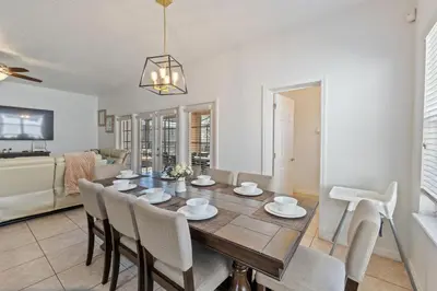 a dining room and living room with a table and chairs at Enjoyable 6BR Home Near Disney in Orlando