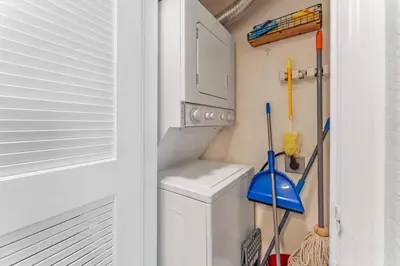 a utility room with a washing machine and cleaning implements at Mickey's Magical Townhome Venetian Bay Villages in Kissimmee