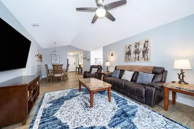 a living room with a couch and a flat screen tv at Private Paradise! Stunning south-facing pool home in Kissimmee
