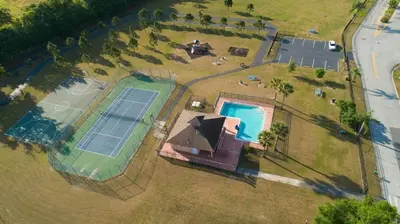 an overhead view of a house with two tennis courts at Private Paradise! Stunning south-facing pool home in Kissimmee