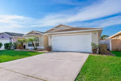 a house with a white garage in a yard at Private Paradise! Stunning south-facing pool home in Kissimmee