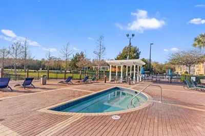 a swimming pool with chairs and a pavilion in a park at The Villas at Seven Dwarfs - 2624 Mickey Villa - Near Disney - Water Park in Kissimmee
