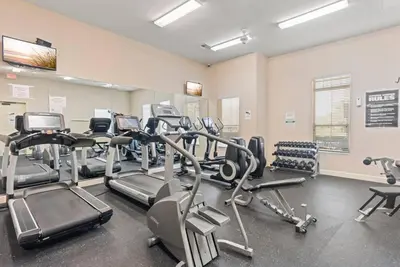 a gym with treadmills and ellipticals in a room at The Villas at Seven Dwarfs - 2624 Mickey Villa - Near Disney - Water Park in Kissimmee