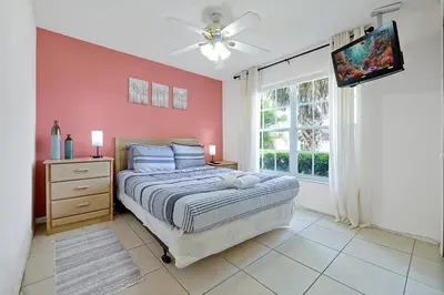 a bedroom with a bed and a ceiling fan at Minutes from Disney - Entertainment Haven with Pool in Orlando