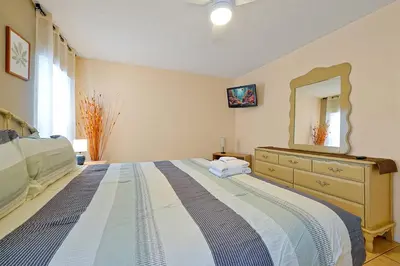 a bedroom with a bed with a dresser and a mirror at Minutes from Disney - Entertainment Haven with Pool in Orlando