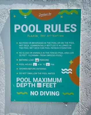 a sign on a wall that says pool rules at Impeccably cozy hotel room Developer Inn Express in Kissimmee