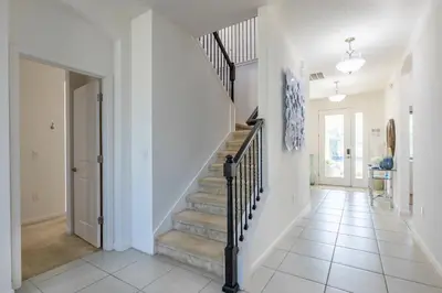 a staircase in a home with white walls at Beautiful and cozy home at Sonoma Resort in Kissimmee