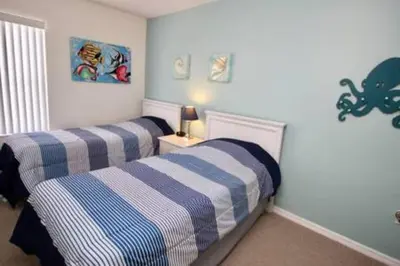 a bedroom with two beds with blue and white stripes at Perfect vacation Gated Resort with Private Pool in Kissimmee