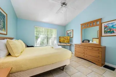 a bedroom with a bed and a dresser and a window at Spacious Bright Close to Disney with Pool and Gym in Kissimmee