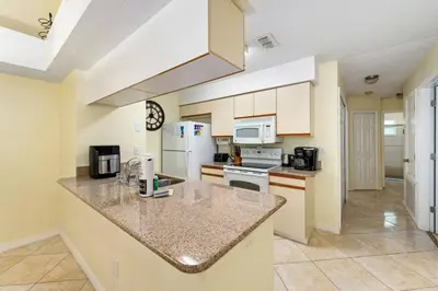 a large kitchen with a counter top and appliances at Spacious Bright Close to Disney with Pool and Gym in Kissimmee