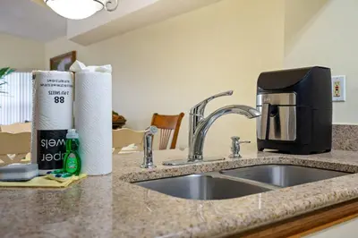 a kitchen counter with a sink and a coffee maker at Spacious Bright Close to Disney with Pool and Gym in Kissimmee