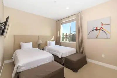 a hotel room with two beds and a bike on the wall at Snow White Home Disney (53360775) in Orlando