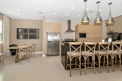 a kitchen with a table and a stainless steel refrigerator at Snow White Home Disney (53360775) in Orlando