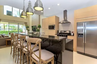 a kitchen with a bar with chairs and a refrigerator at Magical Disney Home (45366427) in Orlando