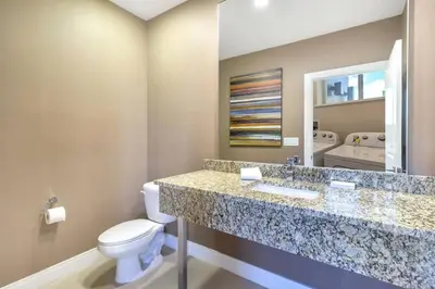 a bathroom with a toilet and a granite counter top at Magical Disney Home (45366427) in Orlando