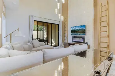 a living room with white furniture and a large window at Fantasy Disney Home (45858326) in Orlando