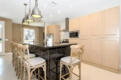 a kitchen with a bar with stools and a counter at Disney Dream Home (7662508) in Orlando