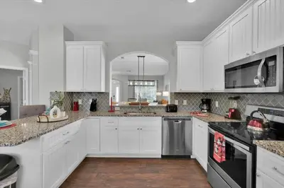 a large white kitchen with white cabinets and appliances at Royal Retreat in Orlando