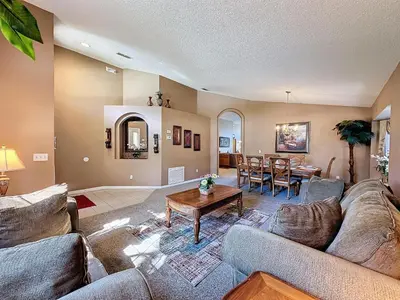 a living room with couches and a dining room at Four Bed in Emerald Island Resort mins to Disney in Kissimmee