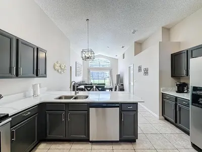 a kitchen with black cabinets and a sink at Five Star Home Private Pool & Jaccuzzi*Free Wi-Fi* in Kissimmee