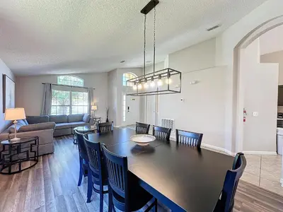 a dining room and living room with a table and chairs at Five Star Home Private Pool & Jaccuzzi*Free Wi-Fi* in Kissimmee