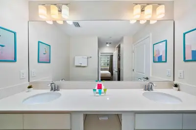 a bathroom with two sinks and a large mirror at 3120 Paradox Circle 104 in Kissimmee