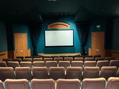 an empty auditorium with chairs and a screen at 4 bed Single Level Home in Windsor Palms Sleeps 8 in Kissimmee
