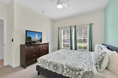 a bedroom with a bed and a dresser with a tv at City Palm Villa in Orlando