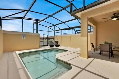 a swimming pool on a patio with a table and chairs at City Palm Villa in Orlando