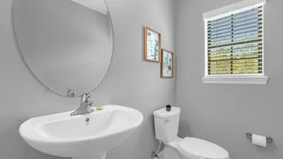 a bathroom with a sink and a mirror and a toilet at Sunny Summer Stay - Renovated TownHome by Disney! in Orlando