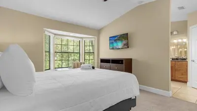 a bedroom with a large white bed and a window at Family Summer Trip - Renovated TownHome by Disney! in Orlando