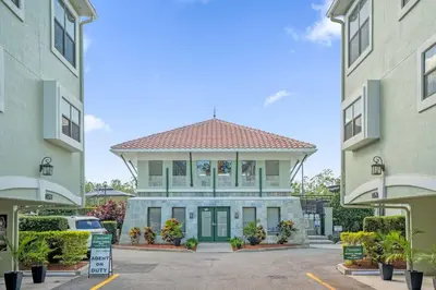 a building in a parking lot between two buildings at Sunny Summer in FL - Relax in a TownHome by Disney! in Orlando