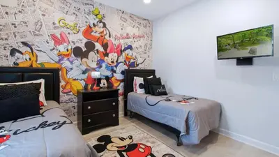 a bedroom with a mural of mickey mouse on the wall at Paradise Pines Villa in Orlando