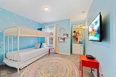 a bedroom with a bunk bed and a tv in it at 8953 Candy Palm Road in Kissimmee
