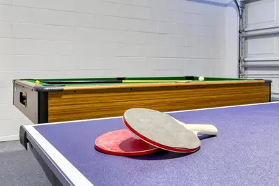 a ping pong table with two ping pong paddles on top of it at Stunning 5 bedroom pool home in gated community minutes from Disney in Kissimmee