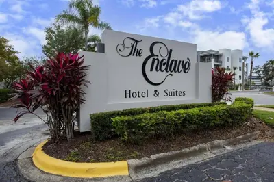 a sign for the nellales hotel and suites at 6165 Carrier Drive Unit 1802 Building 1 in Orlando