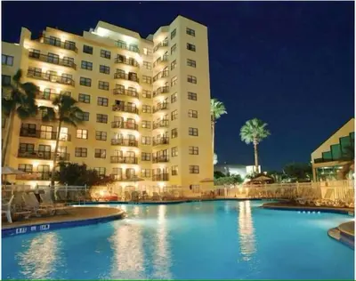 a large building with a large swimming pool at night at 6165 Carrier Drive Unit 1802 Building 1 in Orlando