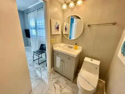 a bathroom with a toilet and a sink and a mirror at 6165 Carrier Drive Unit 1802 Building 1 in Orlando