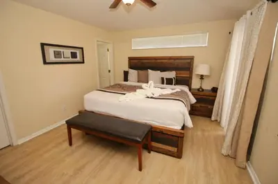 a bedroom with a large bed and a chair at Gorgeous 4 Bed Home In Gated Community in Kissimmee