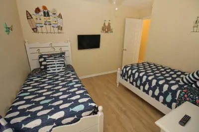 a bedroom with two beds and a tv at Gorgeous 4 Bed Home In Gated Community in Kissimmee